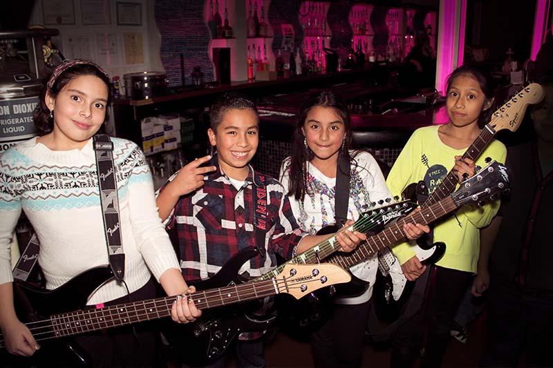 Kids playing bass guitar after completing bass guitar program